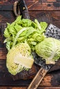 Sliced Savoy cabbage on cutting board. Dark wooden background. Top view