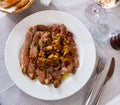 Sliced scottana beef tagliata with pan-fried white mushrooms