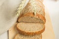 Sliced slices of coarse rye bread on a wooden cutting Board with a linen cloth and rye ears, the concept of a bakery and small Royalty Free Stock Photo