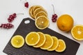 Sliced slices of fresh orange on a cutting board. Half and whole orange. Bunches of frozen red berries Royalty Free Stock Photo