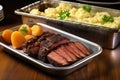 sliced smoked beef brisket on a metal tray with a side of potato salad Royalty Free Stock Photo