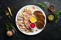 Sliced smoked meat and salami with sauce on a white plate. Royalty Free Stock Photo