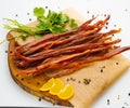 Sliced smoked salmon belly with fresh parsley. Isolated over white background Royalty Free Stock Photo