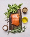 Sliced smoked salmon with parsley and rosemary, oil and spices on a cutting board wooden rustic background top view Royalty Free Stock Photo