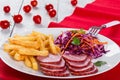 Sliced smoked veal fillet, french fries and red cabbage salad with carrots cut into strips and parsley dressing with vinegar and Royalty Free Stock Photo