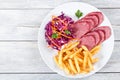 Sliced smoked veal fillet, french fries and red cabbage salad Royalty Free Stock Photo