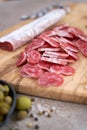 Sliced Spanish sausage fuet salami and vegetables on a domestic kitchen