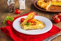 Sliced Spanish tortilla, a traditional dish with eggs and fried potatoes on a clay plate on a wooden background. Potato recipes Royalty Free Stock Photo