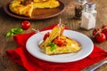 Sliced Spanish tortilla, a traditional dish with eggs and fried potatoes on a clay plate on a wooden background. Potato recipes Royalty Free Stock Photo