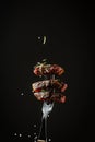 Sliced steak medium rare, dry aged wagyu porterhouse beef steak with large fillet piece on a fork adding rosemary and sea salt in Royalty Free Stock Photo