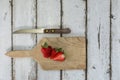 Sliced strawberry on a wooden desk with a knife Royalty Free Stock Photo