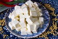 Sliced tofu cubes on plate with soy bean on the side