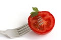 Sliced tomato on fork on isolated white background