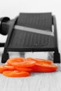 Sliced tomato with mandoline on a grey wood kitchen worktop Royalty Free Stock Photo