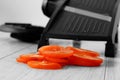 Sliced tomato with mandoline on a grey wood kitchen worktop Royalty Free Stock Photo