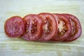 Sliced tomatoes laying on wooden desk. Red tomatos. Royalty Free Stock Photo