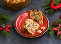 Sliced traditional Scottish Christmas Dundee fruit cake with dried fruit mix, garnished with peeled almonds on a red plate against