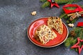 Sliced traditional Scottish Christmas Dundee fruit cake with dried fruit mix, garnished with peeled almonds on a red plate against