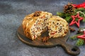 Sliced traditional Scottish Christmas Dundee fruit cake with dried fruit mix, garnished with peeled almonds on a wooden board