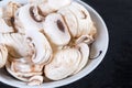 Sliced uncooked button mushrooms in bowl, fragment close-up Royalty Free Stock Photo