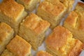 Sliced up corn bread on a white plate on the kitchen table waiting to be eaten