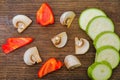 Sliced vegetables on a cutting wooden board: mushrooms, zucchini, red bell pepper Royalty Free Stock Photo