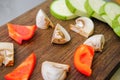 Sliced vegetables on a cutting wooden board: mushrooms, zucchini, red bell pepper Royalty Free Stock Photo