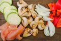 Sliced vegetables on a cutting wooden board: mushrooms, zucchini, red bell pepper Royalty Free Stock Photo