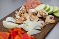 Sliced vegetables on a cutting wooden board: mushrooms, zucchini, red bell pepper Royalty Free Stock Photo