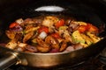 Sliced vegetables with white mushrooms, zucchini, cherry tomatoes, red onions. Vegan dish cooking in frying pan, extreme close up