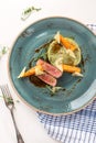 Sliced venison fillet steak with mashed potato and vegetables on blue plate Royalty Free Stock Photo