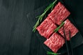 Sliced wagyu marbled beef for yakiniku on plate on black background, Premium Japanese meat and stick