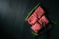 Sliced wagyu marbled beef for yakiniku on plate on black background, Premium Japanese meat Royalty Free Stock Photo