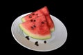 Sliced watermelon on a white plate with black background Royalty Free Stock Photo