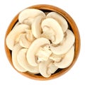 Sliced white champignon mushrooms in wooden bowl