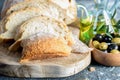 Sliced white homemade bread on the kitchen cutting board, olive oil and olives on the dark background closeup. Healthy Royalty Free Stock Photo