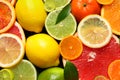 Sliced and whole citrus fruits with leaves as background