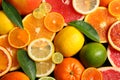 Sliced and whole citrus fruits with leaves as background Royalty Free Stock Photo