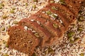 Sliced whole-grain bread, sprinkled with grains on a wooden board. Close-up, macro Royalty Free Stock Photo