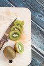 Sliced and whole kiwi fruit on a chopping Board and knife, wooden background Royalty Free Stock Photo