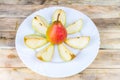 Sliced and whole pears in white plate, rustic wooden table Royalty Free Stock Photo