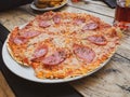 sliced whole salami pizza on a wooden table Royalty Free Stock Photo