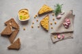 Sliced whole wheat bread with hummus, chickpea and garlic on the grey concrete backdrop. Royalty Free Stock Photo