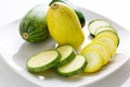 Sliced yellow and green zucchini`s on a white plate sitting on a kitchen table waiting to be consumed Royalty Free Stock Photo