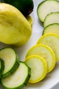 Sliced yellow and green zucchini`s on a white plate sitting on a kitchen table waiting to be consumed Royalty Free Stock Photo