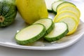 Sliced yellow and green zucchini`s on a white plate sitting on a kitchen table waiting to be consumed Royalty Free Stock Photo