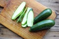 Sliced zucchini on a round wooden cutting board. Close-up of fresh young squash with water drops. Organic vegetables. Royalty Free Stock Photo