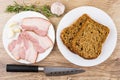 Slices of bacon with garlic and rosemary. Plate with bread Royalty Free Stock Photo