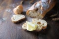 Slices from baguette or French bread with a piece of butter on dark rustic wood, copy space Royalty Free Stock Photo