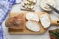 Slices of baguette with tofu cream cheese and rosemary on white wooden table, flat lay Royalty Free Stock Photo